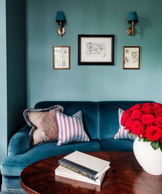 Blue room, blue velvet sofa, wooden round table