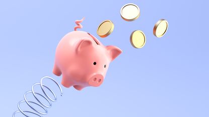 A piggy bank appears to bounce off of a spring into the air as gold coins fly out of it.
