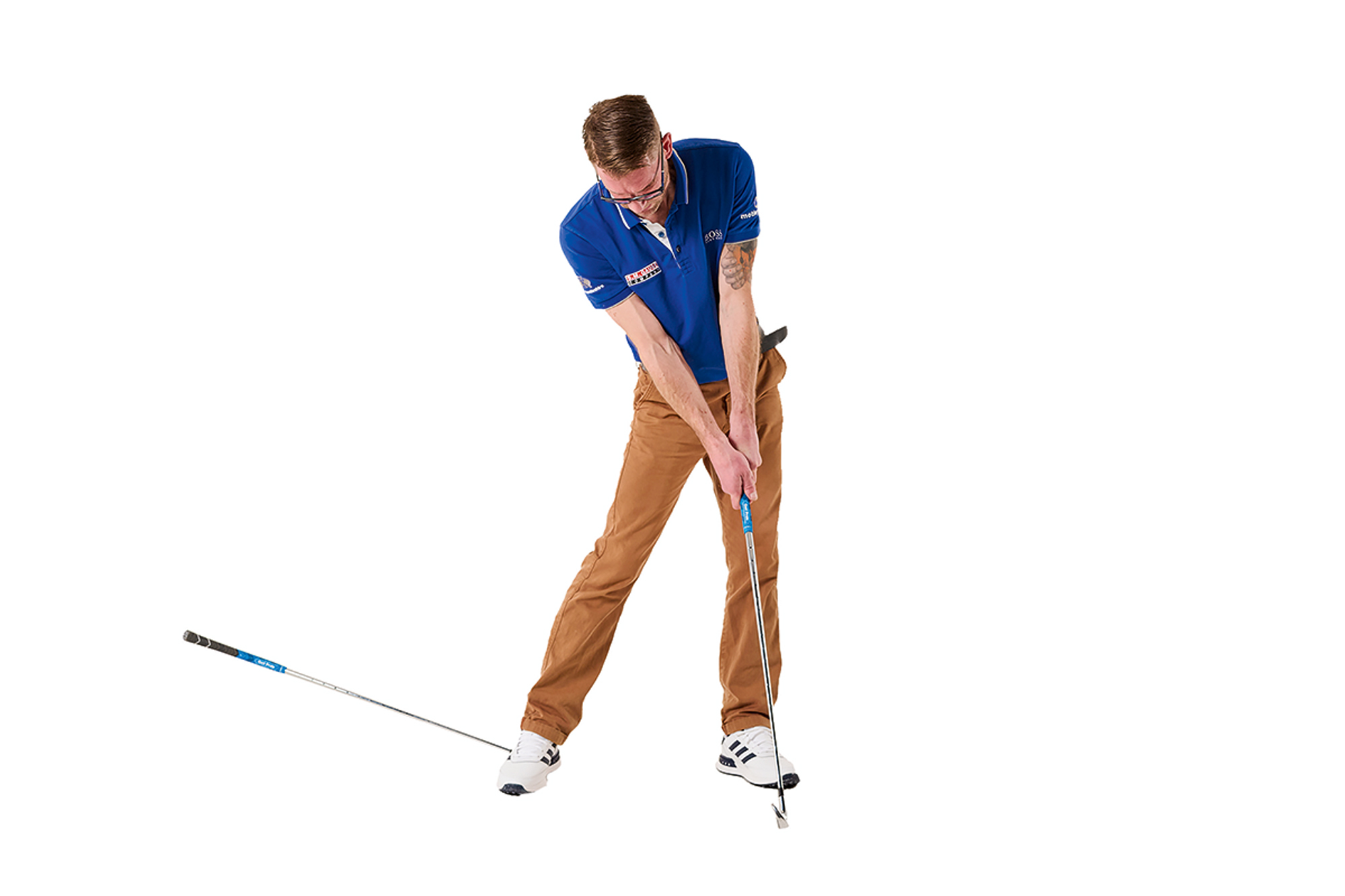 Tom Motley demonstrating the correct trail leg position at impact in the golf swing, with the club under his trail foot still off the ground as pressure is applied