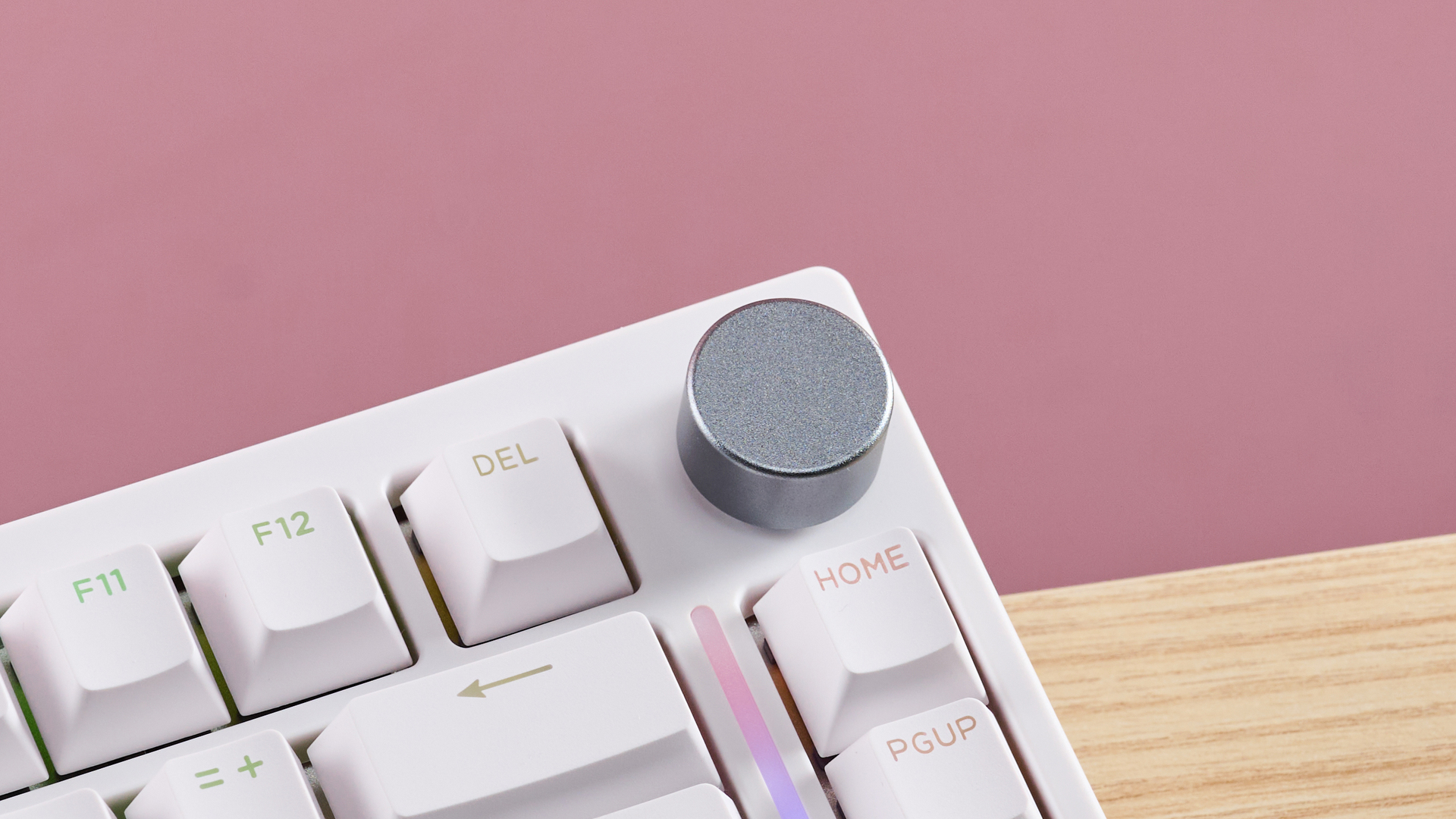 Close-up of volume wheel on Gamakay TK75HE V2 on desk with pink wall in background