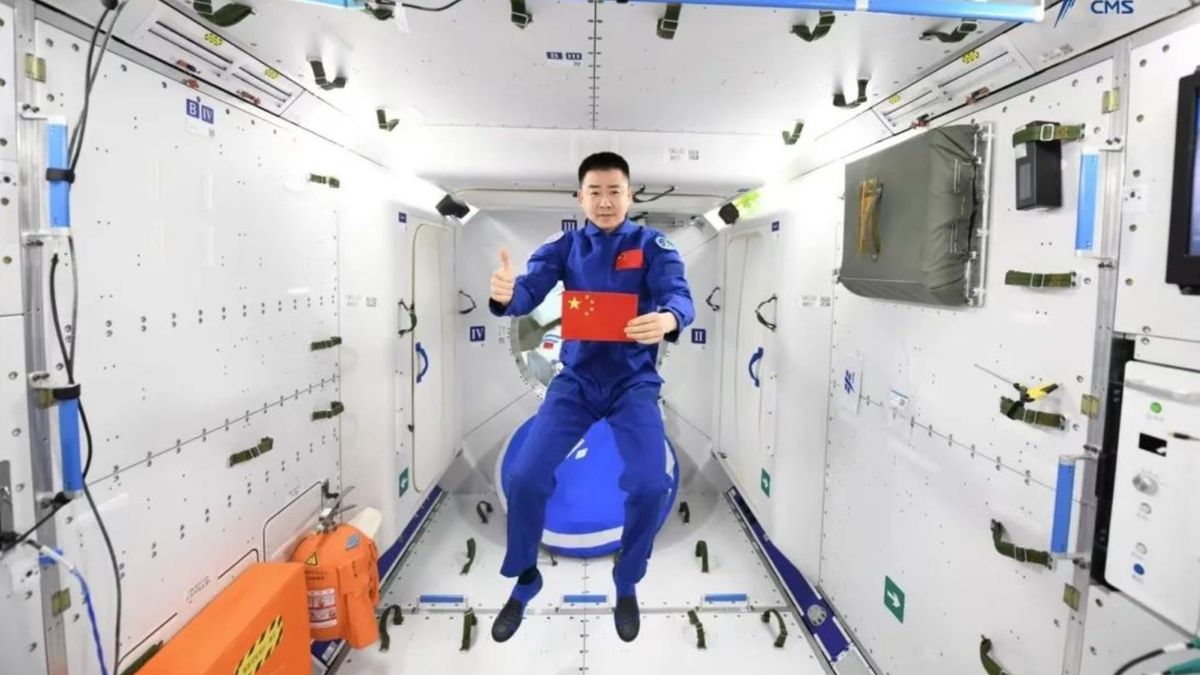 Astronaut Chen Dong posing with a Chinese flag aboard the Tiangong space station.