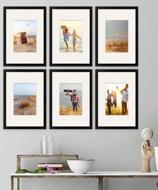 family photos in black frames on a grey wall