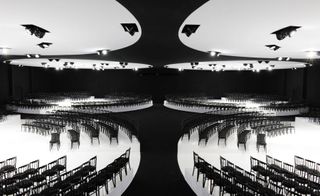 black and white interior photo of the Dior show space with chairs lined up in curved lines