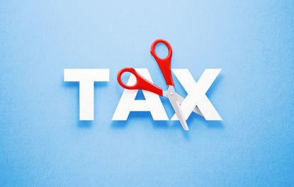 scissors cutting the word taxes against light blue background