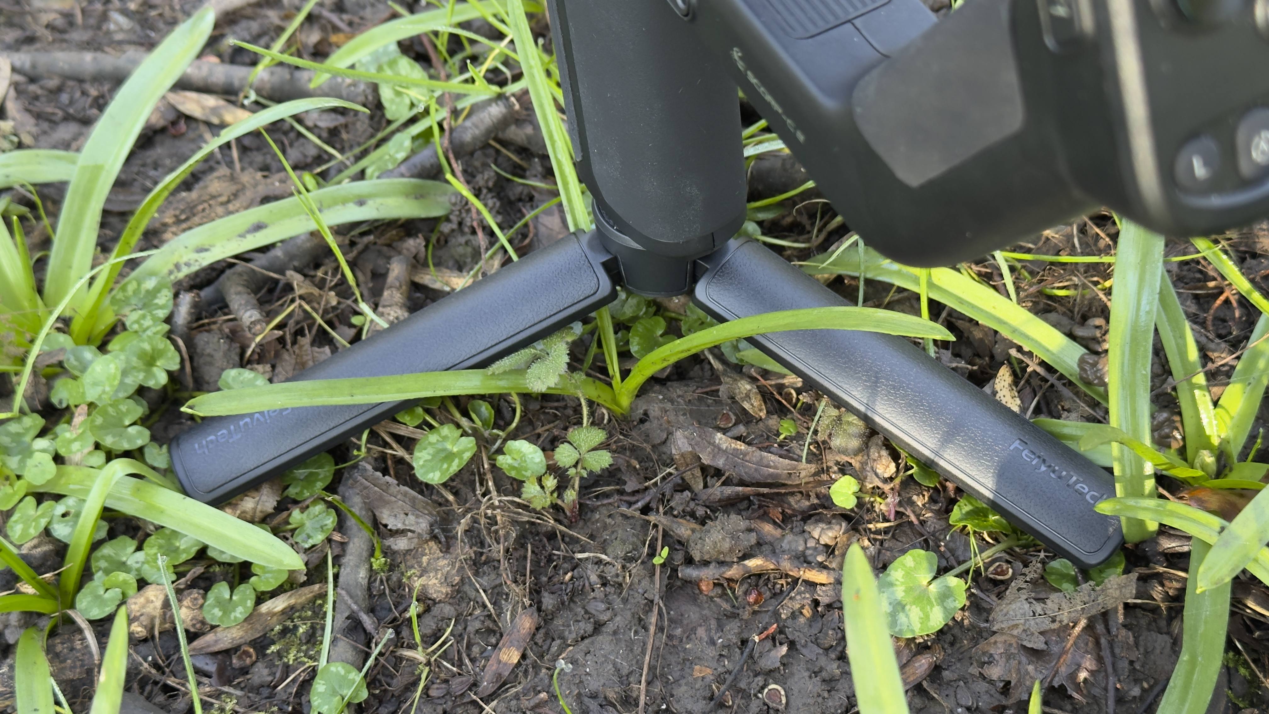 Fold-out mini tripod legs extended beneath the base of the gimbal handle
