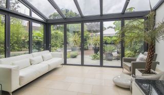 black grey conservatory structure with view of garden
