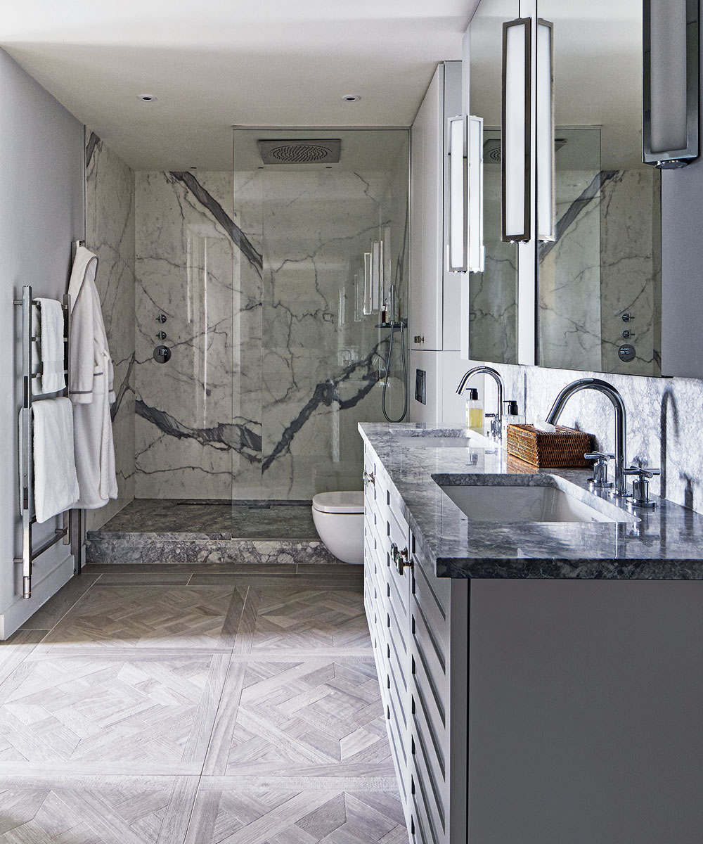 A marble bathroom with a walk in shower and double vanity unit