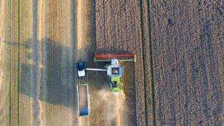 An aerial photo of a tractor harvesting crops in a field