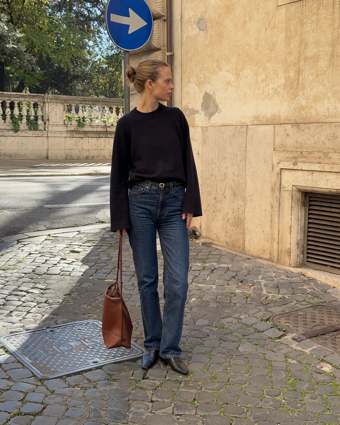 Influencer @claradyrhauge wears cigarette jeans with sock boots and a navy jumper.
