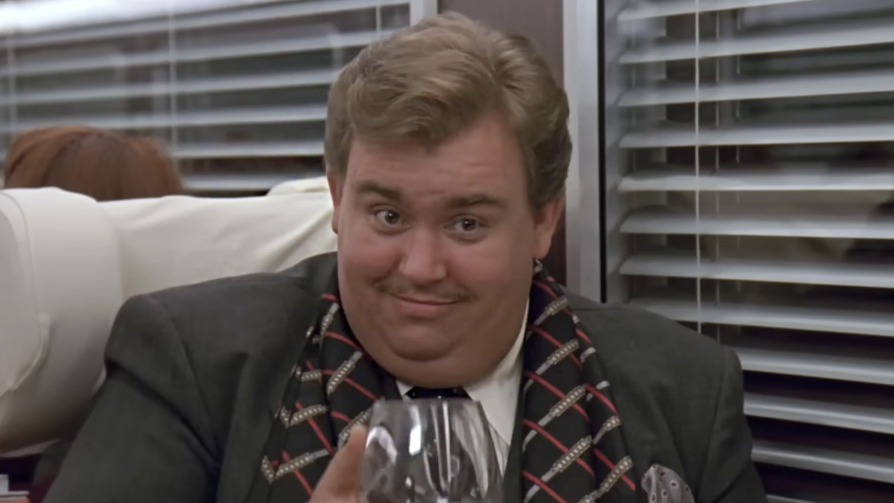 John Candy&#039;s Augie Morosco raising a glass of wine in the dark comedy &#039;Once Upon A Crime.&#039;