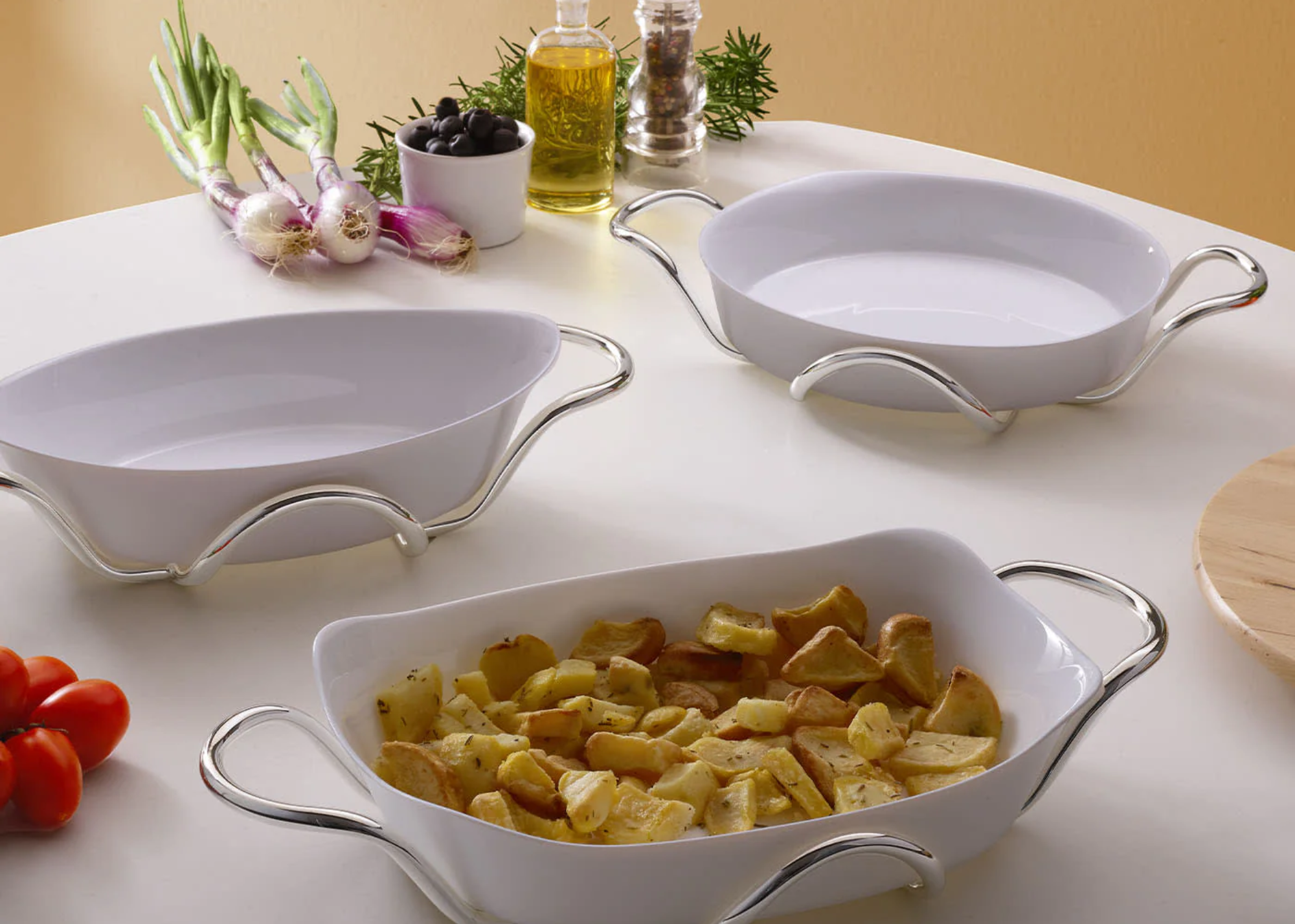 A set of ceramic oven dishes with silver holders on a table with spices