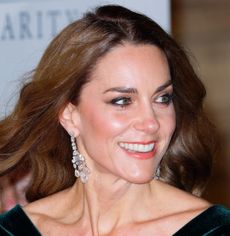 Princess Kate wearing a green gown and diamond chandelier earrings and smiling