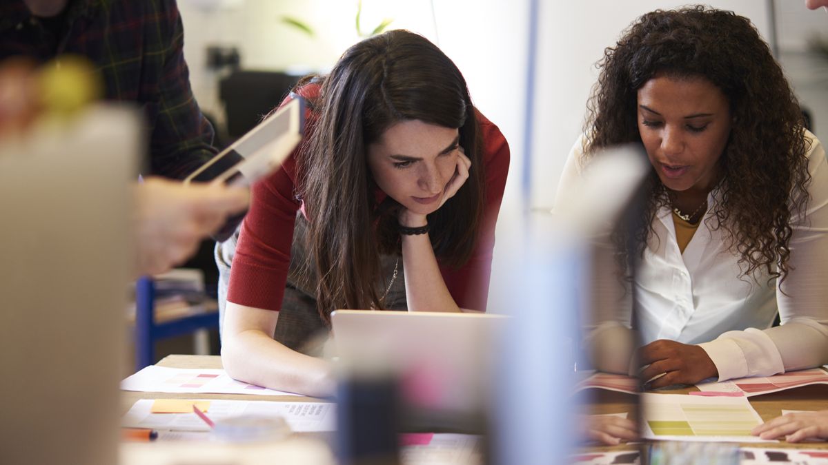 Students working at a table with a laptop