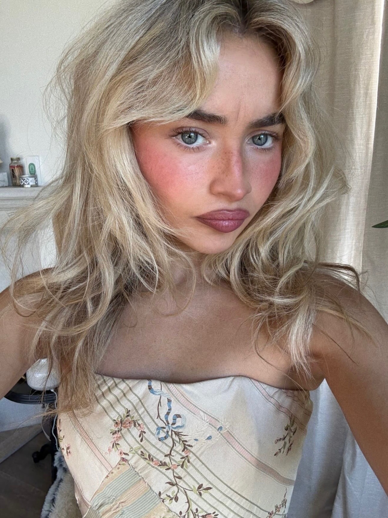 Sabrina Carpenter wearing a bright pink blush on her nose and cheeks