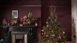 Burgundy red living room with jewel colored decorated Christmas tree with artificial hydrangea Christmas tree topper idea