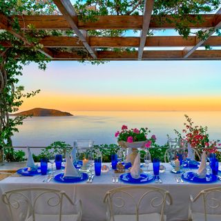 balcony area with dining table and blue dinner platters and sea view