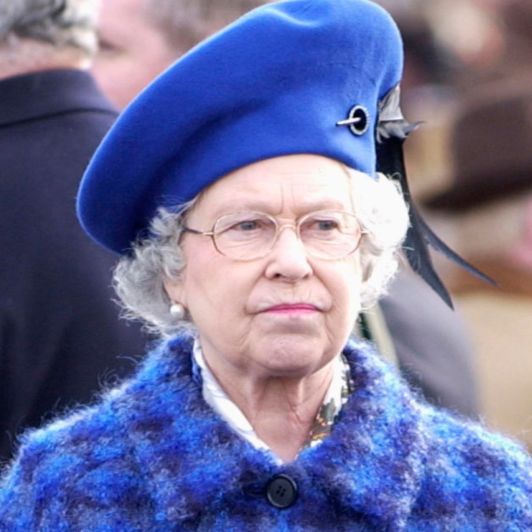 Queen Elizabeth Il Looking Serious Before The Race On Gold Cup Day At The Cheltenham National Hunt Festival While Wearing a Blue and Purple checkered coat and a royal blue hat