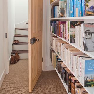 white room with book shelf and carpet flooring