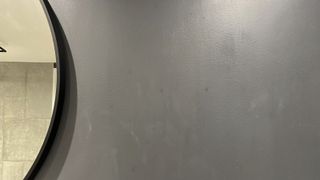 grey painted bathroom wall with water streaks
