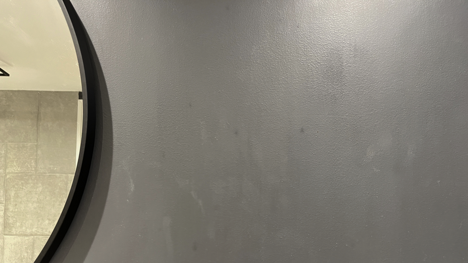 grey painted bathroom wall with water streaks