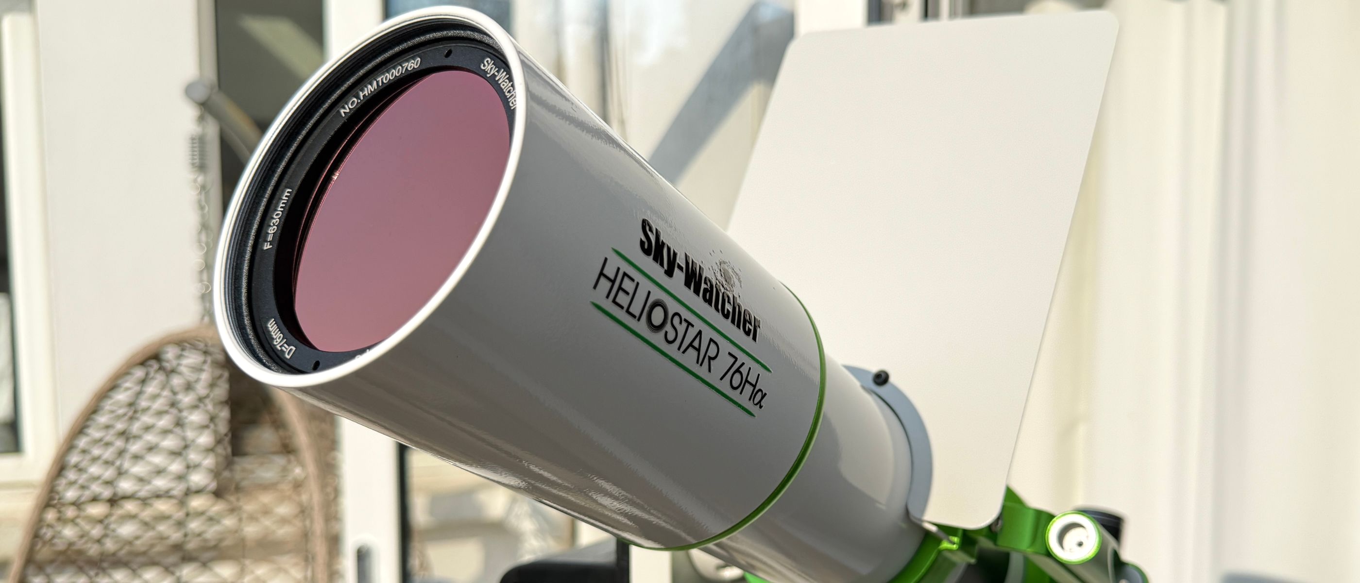 The aperture of the Sky-Watcher Heliostar 76mm H-alpha solar telescope with furniture in the background. 