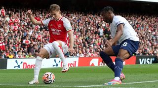 Arsenal's Martin Odegaard and Tottenham's Destiny Udogie compete for the ball in the North London derby at the Emirates Stadium in September 2023.