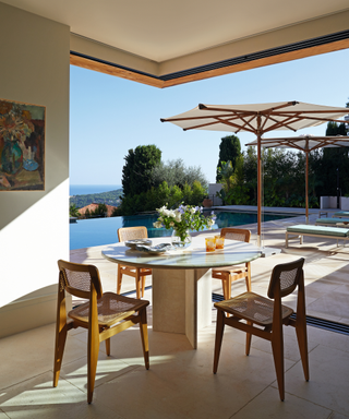 sun terrace overlooking pool with dining table