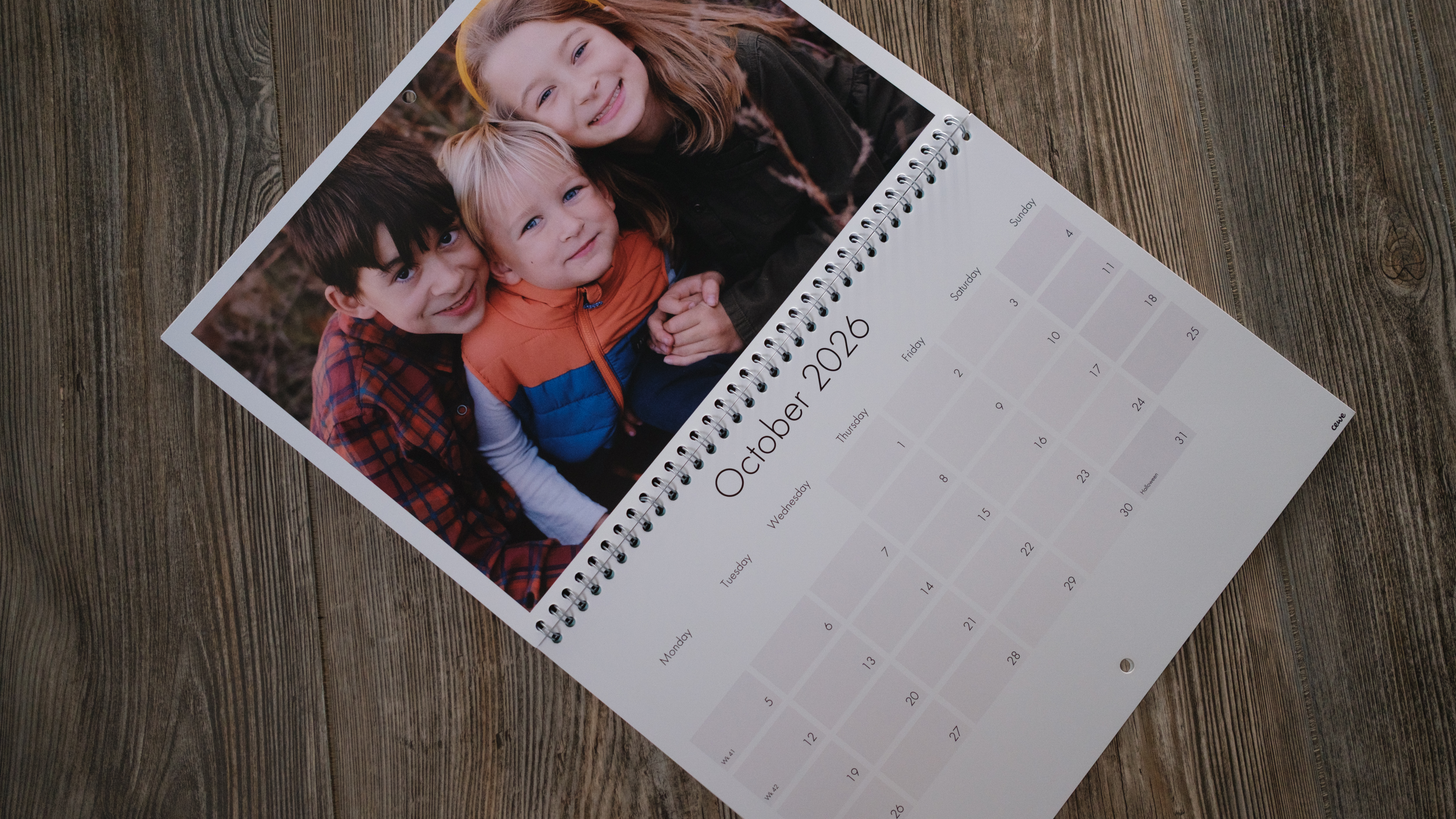 A photo calendar from CEWE on a wood background