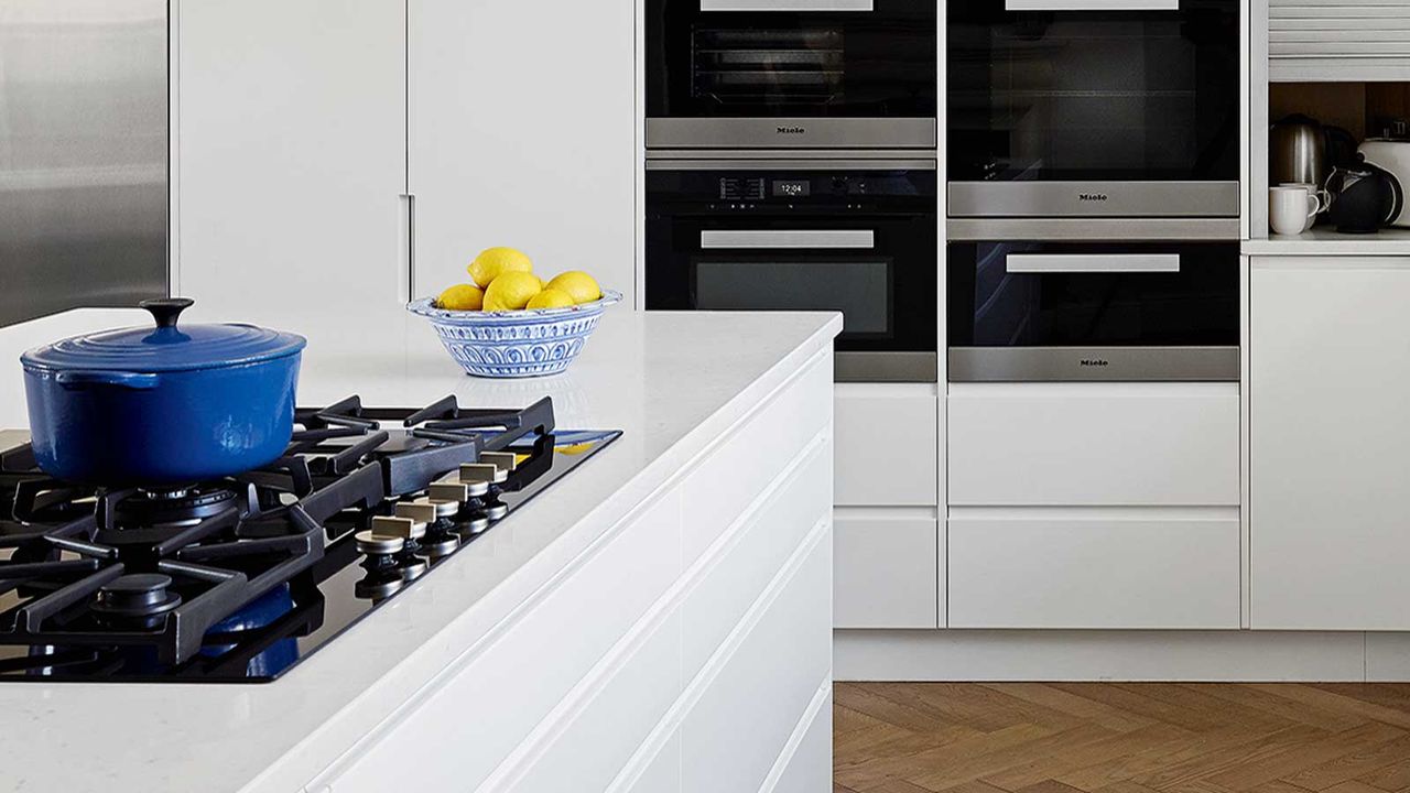 white kitchen with gas stove and blue enameled cast iron pot