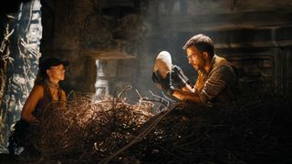 Scarlett Johansson in a dinosaur nest and Jonathan Bailey holding a dinosaur egg in Jurassic World Rebirth