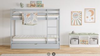 The Saatva Bunk and Trundle Mattress photographed in a stylish kids room with sun and moon prints on the wall