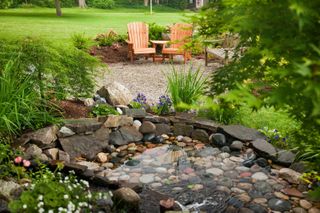 garden pond ideas: pond with pebbles and surrounding plants