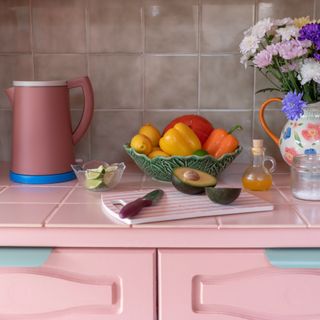 pink kitchen with painted tiles and fruit bowl