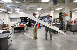 Aerospace engineering doctoral student Adrien Bouskela (left) and aerospace and mechanical engineering professor Sergey Shkarayev hold an experimental sailplane that could inform future Martian designs.