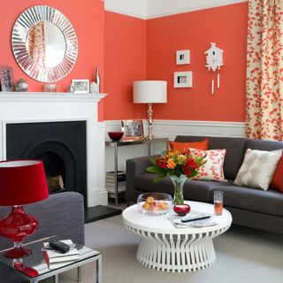 Coral living room with dark grey sofa, grey carpet and white fireplace and coffee table