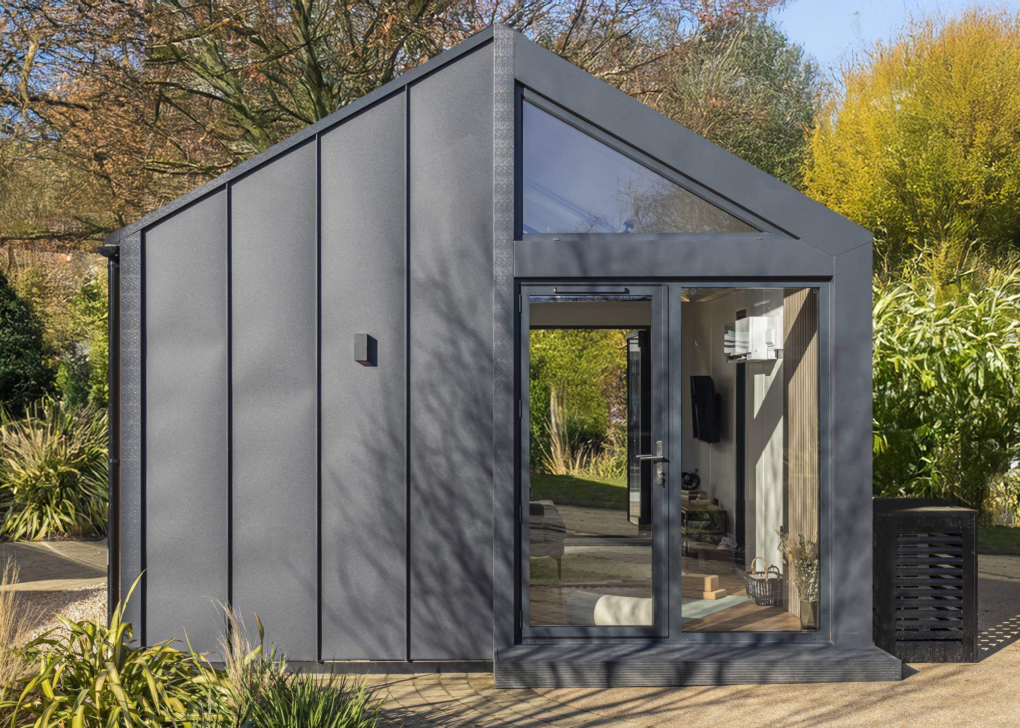 black zinc clad garden room with pitched roof and patio doors