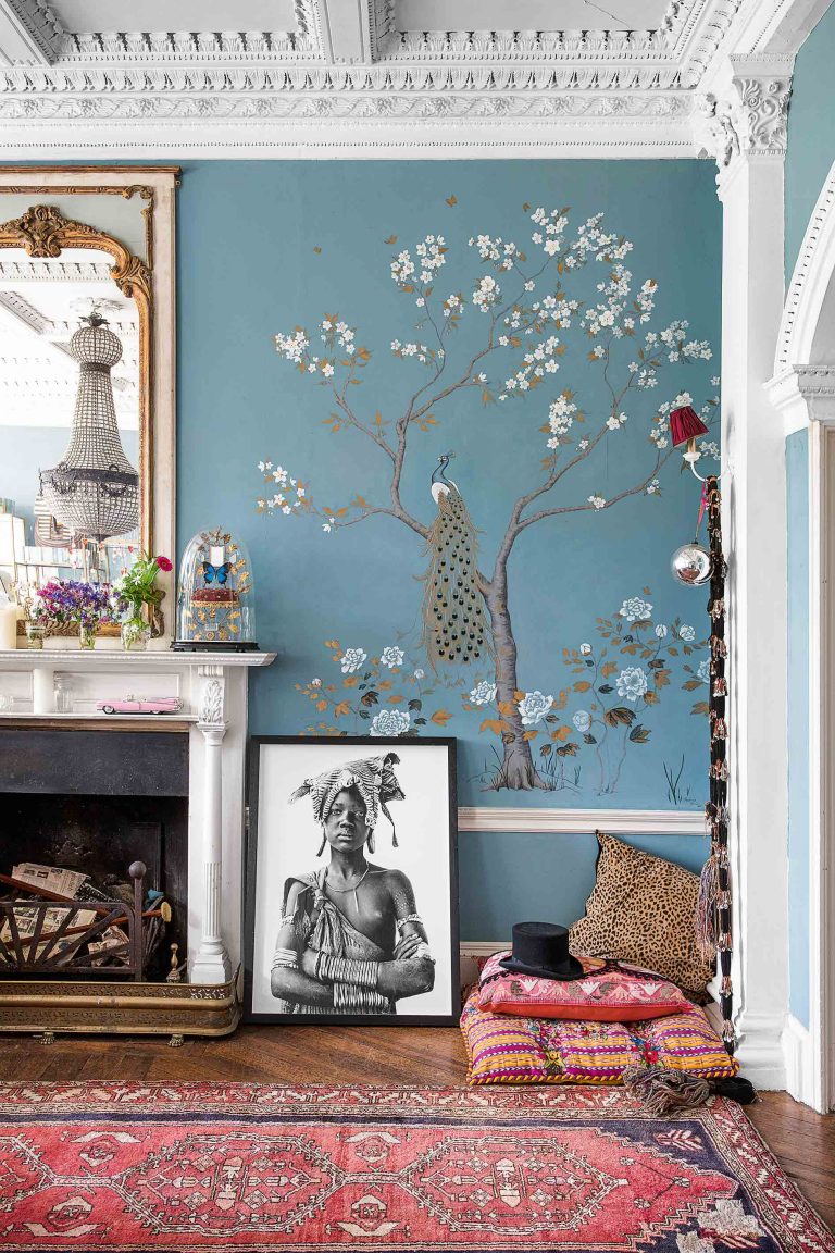 Living room with blue painted mural, Persian rug and white fireplace