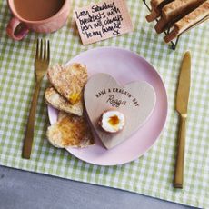 Oakdene Designs Personalised 'Have A Cracking Day' Dippy Egg Board on pink plate with boiled egg, toast, gold cutlery and mug of tea