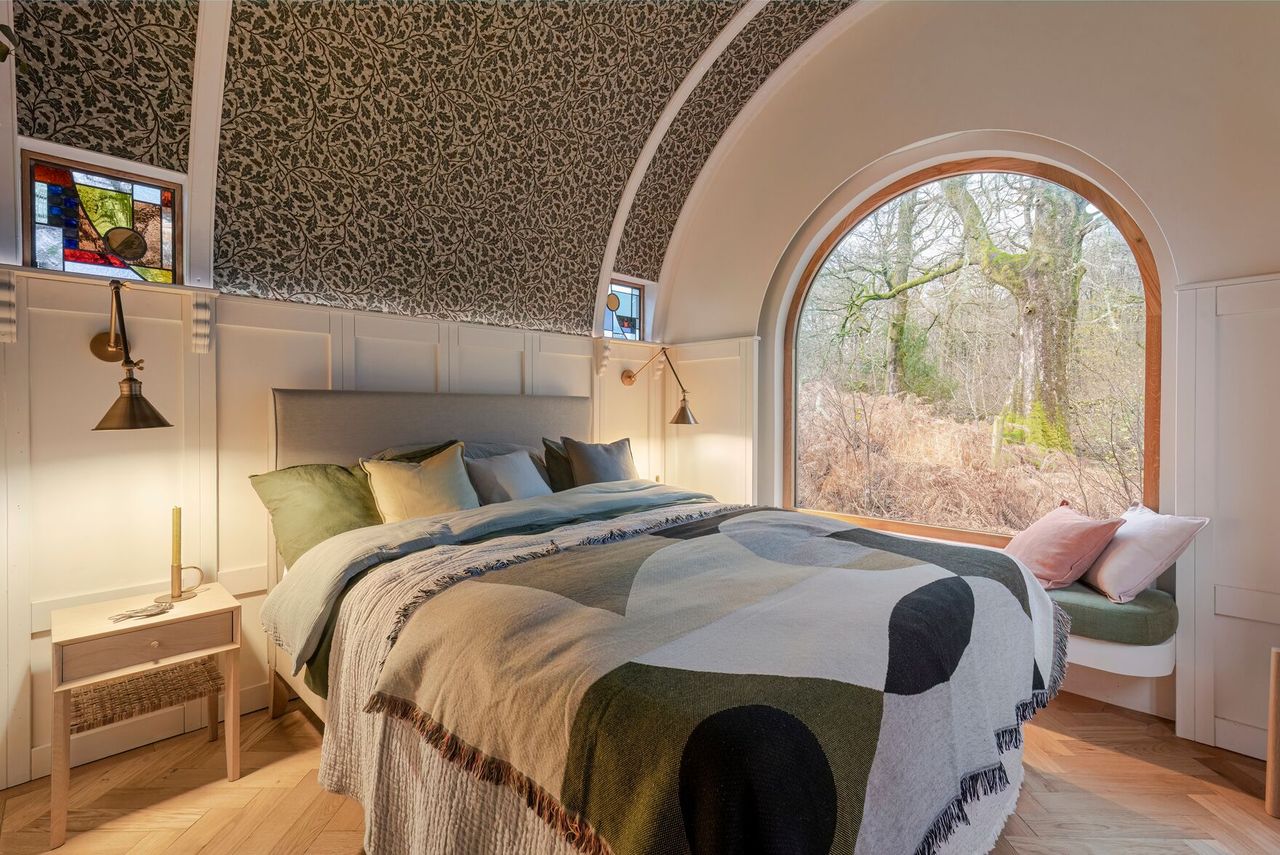A double bed inside a caravan with a barrel vaulted roof