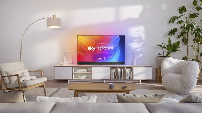 Sky Glass Gen 2 in a modern living room with white furnishings, a wooden coffee table and a selection of plants in the corner.