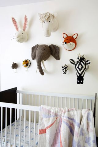 Quirky animal wall art in baby bedroom with cot