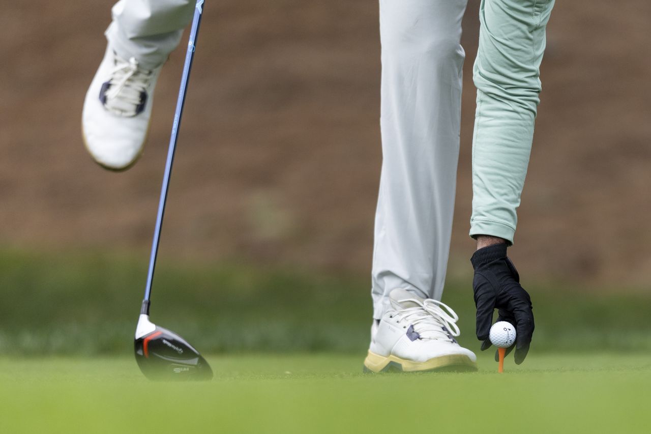 Aaron Rai tees up a golf ball