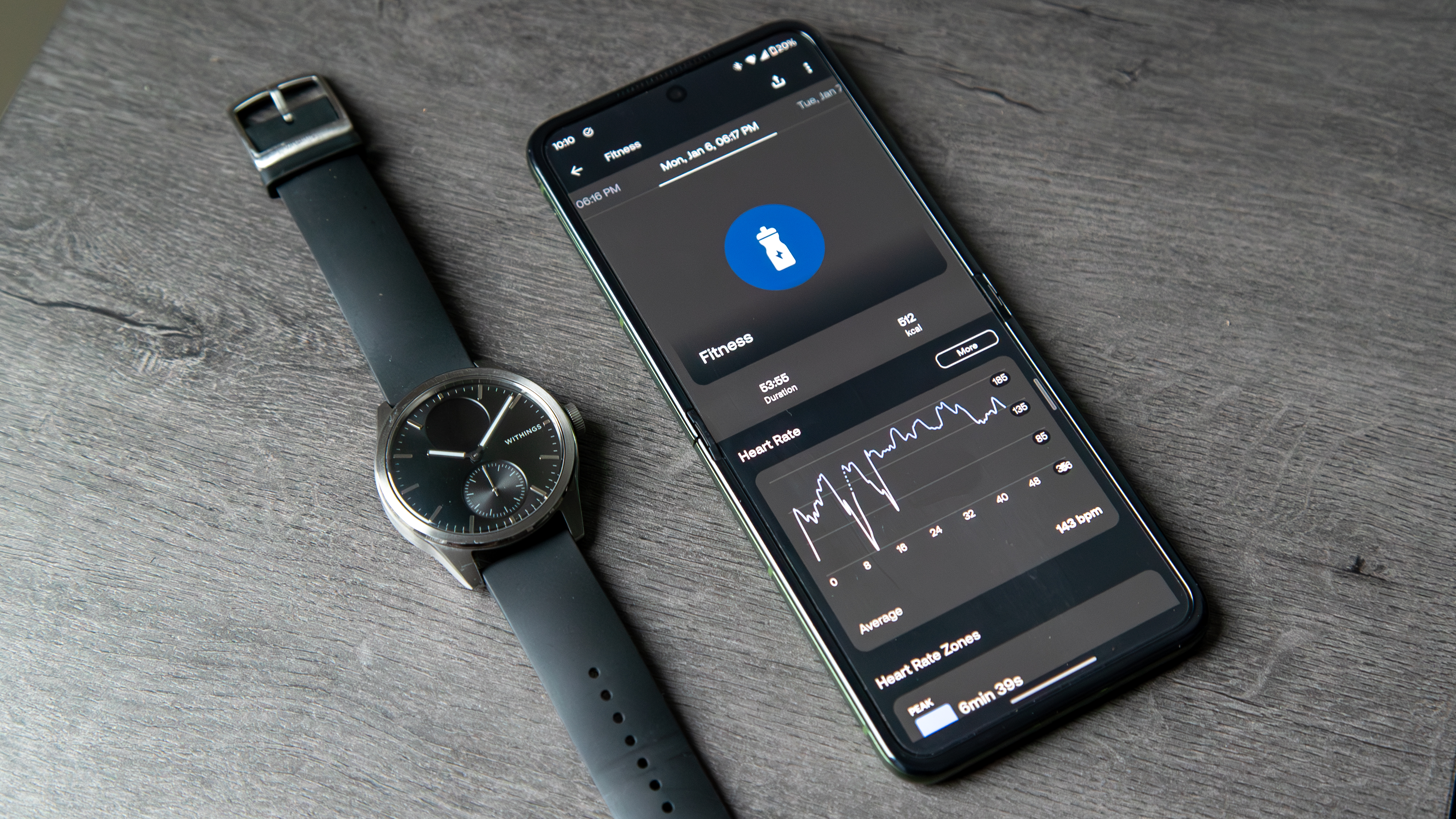 The Withings ScanWatch 2 next to a phone with the Withings app open to a workout.