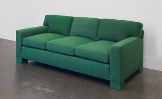 Green material three-seater sofa