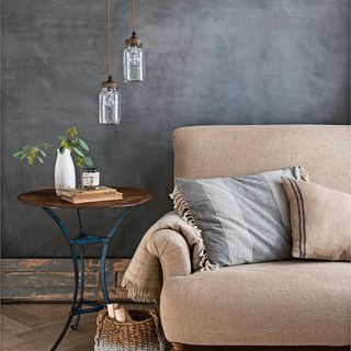 A natural cotton linen sofa with charcoal walls and jars for lights