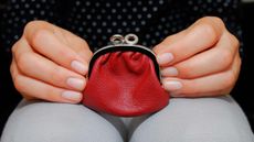 A small red change purse on a woman's lap.