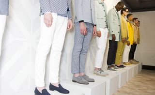 Eight guys wearing the Hardy Amies S/S 2015 collection. They are standing on podiums, each one displaying their Hardy Amies style in different colours including minty green and bright yellow