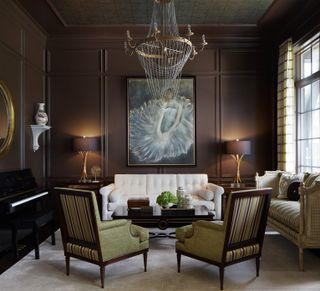 Brown drawing room with white sofa and green armchairs