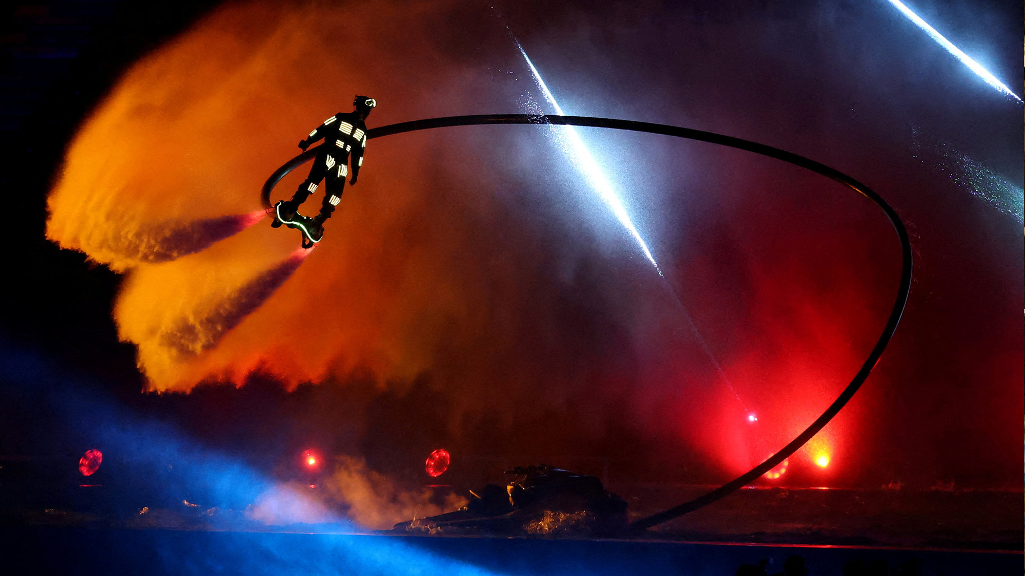 A flyboard performer flies over the stage during the Southeast Asian Games opening ceremony in Bangkok, Thailand