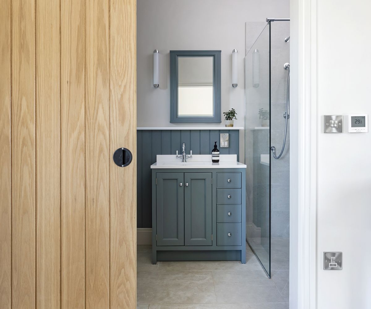 View through a sliding wooden door into a small shower room